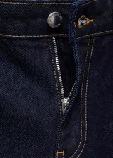 Pantalón de jean de tiro medio color azul oscuro, corte wide leg con cuatro bolsillos y costura ancha en el bajo. Cierre frontal con cremallera y botón.