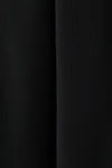 Leggings negros de tiro alto en punto elástico, con pliegues frontales pespunteados y estribos en los tobillos.