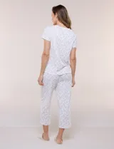 Conjunto pijama de remera de manga corta y pantalón capri blanco con delicado estampado floral en tonos rosados y verdes, confeccionado en tejido acanalado fino con escote redondo y detalle de gota con botón.