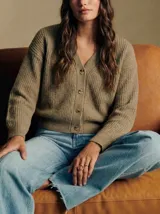 Cardigan de punto acanalado con cuello en V y cierre frontal de botones. Presenta un corte oversize y mangas largas con puños ajustados.