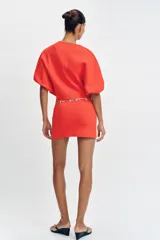 Falda corta de punto con cintura elástica y diseño en evasé de color rojo.