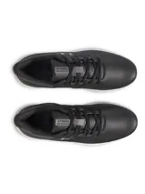 Championes de golf Under Armour, modelo Drive Medal SL, en color negro con detalles en gris y suela blanca. Presentan parte superior de microfibra, mediasuela con tecnología Charged Cushioning para amortiguación y suela exterior sin tacos para mayor flexibilidad y tracción.