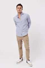 Camisa de manga larga para hombre, color azul claro con microestampado de rayas blancas. Corte slim, cuello clásico y abotonada al frente.