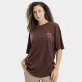 Remera blanca de corte oversized, con cuello redondo y mangas cortas. Presenta un pequeño estampado en el pecho con el logo de la marca Reef en color rojo y detalles de estrellas.