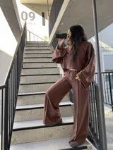 Buzo oversize de color marrón chocolate, con cuello redondo, mangas anchas y diseño con costuras expuestas en contraste. Presenta terminaciones desflecadas en el ruedo y en los puños.