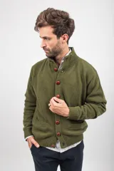 Cardigan de punto color verde oliva, con cuello alto, cierre frontal de botones grandes en tono marrón y bolsillos frontales tipo parche.
