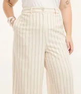 Pantalón ancho estilo pantalona color beige con estampado de rayas verticales finas. Cuenta con elástico en la espalda, bolsillos laterales y traseros, y botón de nácar en la cintura.