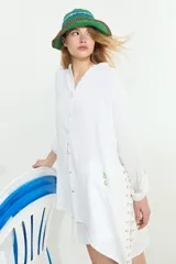Camisa de algodón blanca, de manga larga y corte oversize, con diseño abierto en los laterales ajustable mediante cordón y ojalillos.