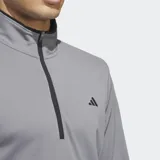 Buzo gris de golf Adidas con medio cierre frontal y logo de la marca en el pecho. Confeccionado en tejido de punto doble ligero y suave.
