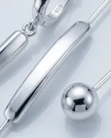 Caravanas colgantes de plata 925 con diseño minimalista compuesto por una pieza curva y una cadena fina terminada en una pequeña esfera.