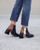 Botinetas de cuero con diseño tricolor en negro, marrón con textura croco y blanco. Presentan taco cuadrado, plataforma y cierre lateral.