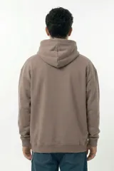 Hoodie color visón con calce relajado, capucha con cordones ajustables y bolsillo canguro frontal. Presenta un estampado pequeño en el pecho con el logo de la marca en estética hand-drawn.