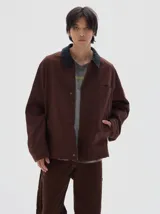 Campera de brim bull color marrón con cuello de pana azul marino en contraste, cierre frontal metálico y bolsillos delanteros. Forro interior de paño cuadrillé.