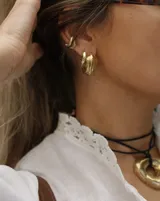 Aros tipo argollas de diseño artesanal con acabado texturizado y forma irregular. Fabricados en bronce y alpaca, con pernos y cierres de plata 925.