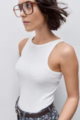 Musculosa de calce ajustado color rojo, confeccionada en algodón con elastano. Presenta escote redondo alto y textura acanalada.