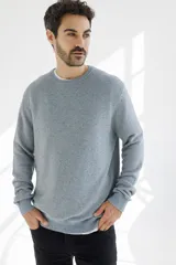 Sweater azul jaspeado de punto con cuello redondo y mangas largas.