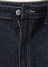 Jeans tiro alto wide leg con diseño de cinco bolsillos y cierre frontal de cremallera y botón.