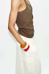 Pack de tres pulseras rígidas de resina con acabado brillante, en colores crema, naranja marmolado y rojo.