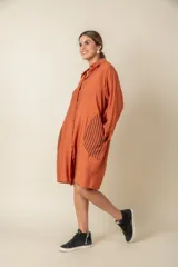 Túnica marrón de viscosa texturizada con cierre de botones, bolsillos laterales y detalle de rayas verticales en los bolsillos.