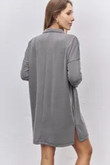 Vestido corto de tejido acanalado en color gris, con cuello polo, cierre frontal de botones y mangas largas con caída de hombros.