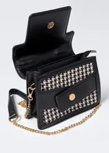 Cartera de mano con estampado pata de gallo en blanco y negro, detalles en cuero sintético negro y correa de cadena dorada.