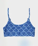 Top deportivo con estampado de escamas azules y blancas, con tirantes finos y espalda deportiva.