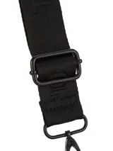 Bandolera Terrano modelo Astrid de color negro, con solapa de textura símil cocodrilo y base lisa. Cuenta con correa ancha regulable con inscripciones de la marca y herrajes metálicos oscuros.