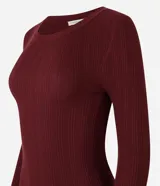 Suéter de punto acanalado color beige, con cuello redondo y mangas largas. Confeccionado en tejido tricot con textura suave y ajuste al cuerpo.