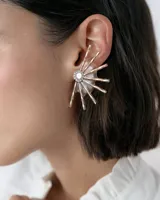 Caravanas tipo ear cuff con diseño de medio sol, compuestas por varillas metálicas plateadas, centro con strass y detalle de resina. Diseño liviano y brillante.