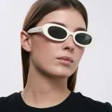 Gafas de sol con montura ovalada color blanco y lentes verdes.