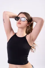 Musculosa estilo halter al cuerpo, de color negro, confeccionada en algodón elastizado con escote cerrado y etiqueta frontal aplicada en el ruedo.
