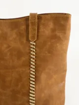 Bolso tipo tote de cuero color marrón claro con costuras verticales decorativas en hilo color crudo.