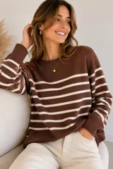 Sweater de tejido de punto con diseño de rayas horizontales en color marrón y crema, con escote redondo a la base y mangas largas.