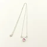 Collar dorado con cadena fina y dije circular negro.