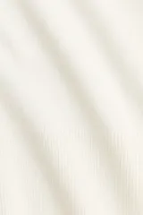 Saco corto en punto fino suave de mezcla de viscosa. Modelo entallado con cuello en V y cierre de botones. Remate acanalado ancho en puños y bajo.