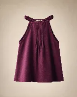 Blusa de lino color bordó, con escote halter y fruncido en el cuello. Presenta tabletas estructuradas en el frente y un diseño amplio y fluido sin mangas.