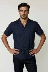 Camisa de manga corta color azul marino, con cuello tipo cubano y cierre frontal de botones.