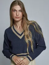 Sweater de punto con escote en V, diseño de estilo preppy en color azul marino con detalles de rayas en contraste color beige en el cuello, puños y ruedo. Presenta mangas largas y un calce cómodo.