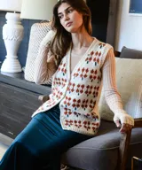 Chaleco tejido de punto color crudo, con diseño floral jacquard en tonos tierra, escote en V y cierre frontal con botones de nácar.