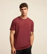 Remera deportiva de hombre con tecnología dry fit, cuello redondo y manga corta. Presenta un diseño liso en color beige con una pequeña etiqueta decorativa en el dobladillo.