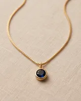 Collar de bronce dorado con cadena fina de eslabones y dije circular con piedra ónix negra en engaste bisel.