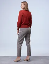 Cardigan rojo tejido en hilado fino, con escote en V y abertura central con botones metálicos.