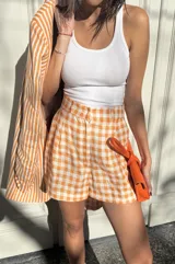 Short sastrero de lino con estampado de rayas verticales naranjas y blancas, corte holgado.