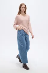 Sweater de tejido acrílico de corte holgado, color rosado, con cuello redondo y mangas 3/4.