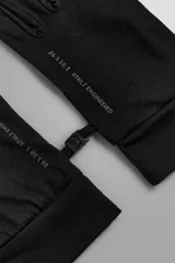 Guantes de running negros, ligeros y ajustados, confeccionados en tejido técnico con mezcla de lana. Cuentan con función táctil en los dedos y un enganche lateral de seguridad para unirlos.