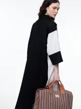 Vestido camisero largo de lino con diseño bicolor en bloques de negro y blanco, cuello camisero, cierre frontal oculto y mangas tres cuartos con silueta holgada.