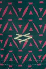 Short de baño verde con estampado geométrico en color rosa y cordón ajustable color amarillo.