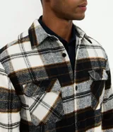 Campera de franela a cuadros con forro de sherpa, cuello polo, cierre frontal con botones y bolsillos delanteros con solapa.