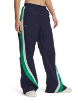 Pantalón deportivo de corte holgado y pierna ancha, confeccionado en tejido de nailon con textura arrugada. Presenta un diseño en color azul marino con paneles laterales en verde y blanco, cintura elástica y botones a presión en los laterales de las piernas.