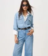 Pantalón wide leg de tiro alto confeccionado en jean de algodón, con pretina con pasacintos, cierre frontal con botón y cremallera, y bolsillos delanteros y traseros.